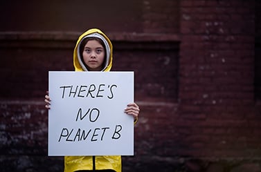 child holding up sign that reads, 