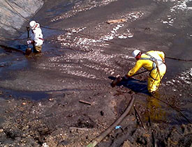 a Covanta Environmental Solutions employee cleaning a waste pit